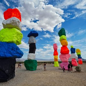 person in green blue and red hat standing on brown sand during daytime